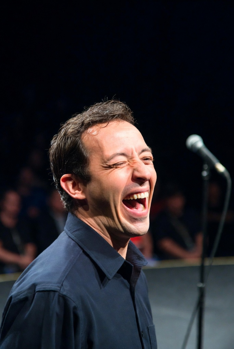 Photo of comedian laughing on stage